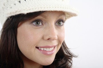 Woman in hat smiling while looking away