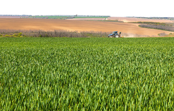 Tractor plough green field in Bulgaria.