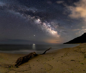 Milky way galaxy over black sea waste shore. Bilion stars in summer night. 