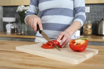 Woman cutting capsicum in the kitchen