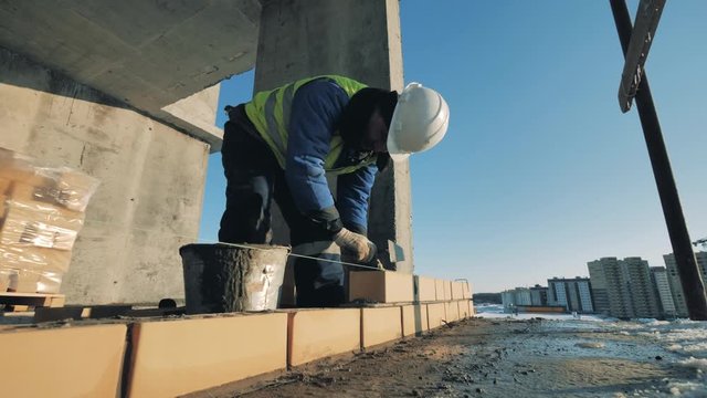 Brick wall is getting constructed by an industrial worker
