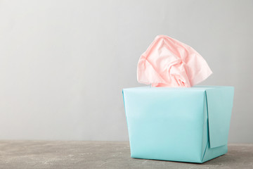 Blue box with paper tissues on grey background with copy space