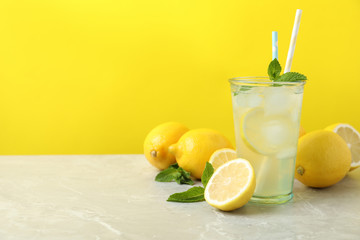 Natural freshly made lemonade on light grey marble table, space for text. Summer refreshing drink