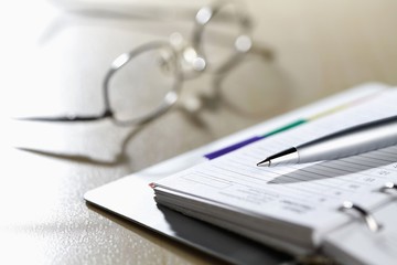 Close-up of organizer with glasses and pen