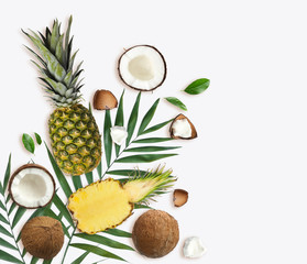 Tropical layout with fresh exotic fruits and green leaves on white background, top view