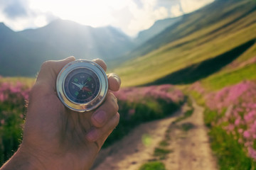 Compass in hand on a background of nature