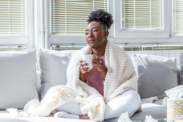 Sick day at home. African American woman has runny nose and common cold. Cough. Closeup Of...