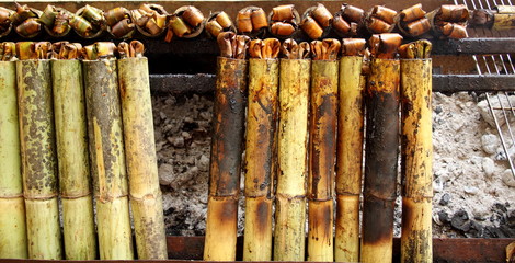 Sticky rice roasted in bamboo join or "Khao Lam" are roasting on stove. In Thailand Khao Lam is favorite thai dessert and must cracked the bamboo before eat.