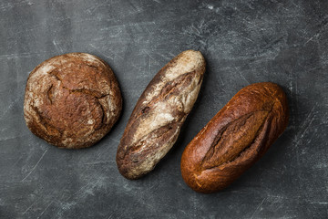 Rustic bread on dark background. Flat lay.