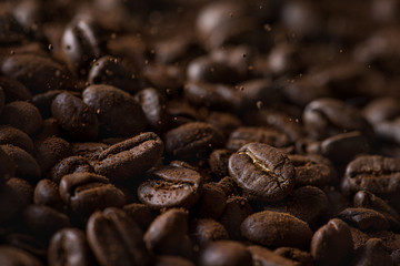 Closeup of falling coffee beans with focus on one in beautiful light