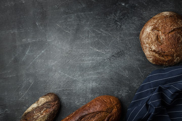 Rustic bread of whole wheat grains on dark background with copy space.