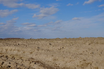 Blue sky over a plowed field. Spring landscape. Agriculture.