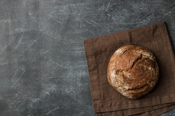 Rustic bread of whole wheat grains on dark background with copy space.