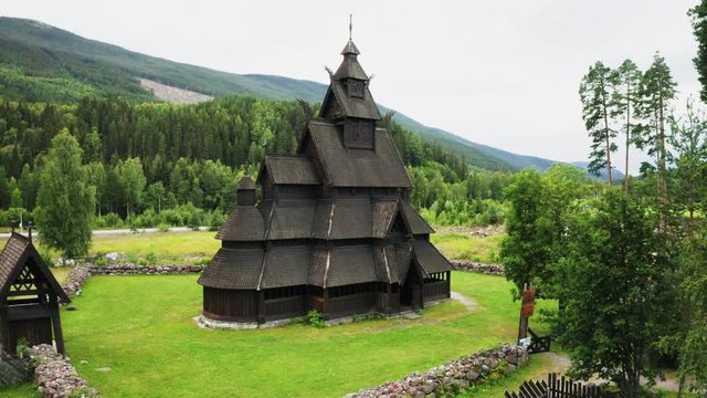 Wooden Structure Of Gol Nye Stave Church With Mountain And Green Forest On The Background In Gol, Buskerud Oslo, Norway. - aerial forward - top-down shot