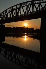 Obraz premium The reflection of the old bridge on the river,The silhouette of the old bridge at sunrise or sunset in the countryside