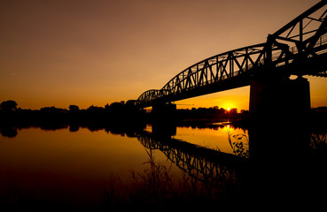 The reflection of the old bridge on the river,The silhouette of the old bridge at sunrise or sunset in the countryside