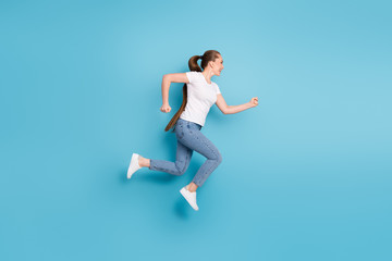Fototapeta na wymiar Full body profile side photo of excited girl listen incredible season discounts jump run copyspace wear good look clothes gumshoes isolated over blue color background