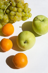 fresh green sweet apples grape orange apricot fruits on white  table