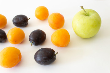 Close up green apple orange apricot dark plum on white background sweet fruits vegan meal low calories diet concept