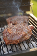 Group grilled ribeye beef steaks on the grill outdoor, background. barbecue season concept, bbq copy space, summer