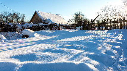 Street in traditional Russian village in snowy frost winter