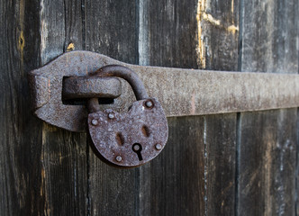 old hanging rusty iron lock on wooden door  © Anatoly