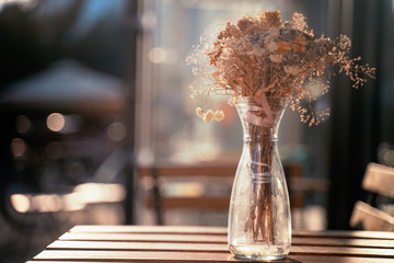 A bouquet of dried flowers on a table of a street cafe, on a summer sunny day