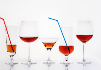 Glass glasses of different sizes with a drink on a white background.