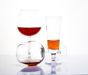 Glass glasses of different sizes with a drink on a white background.