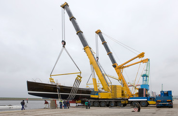 Fototapeta na wymiar Launching of a super super sailing yacht in the harbor of Harlingen. Friesland. Netherlands. Shipbuilding industry. Cranes