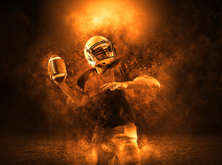 American football sportsman player with ball in action on stadium under lights of background....