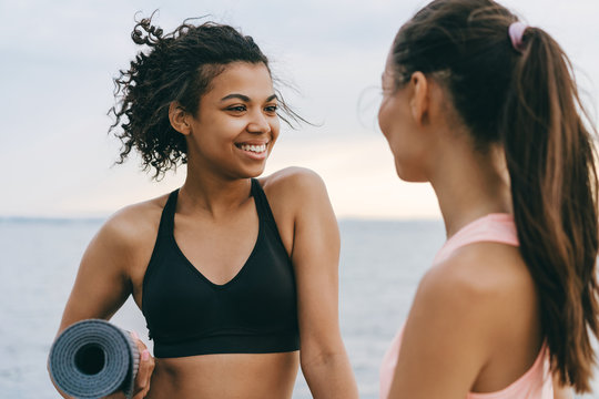 Image of joyful multinational sportswomen talking after workout