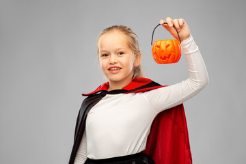 halloween, holiday and childhood concept - happy smiling girl in black dracula cape or costume with...