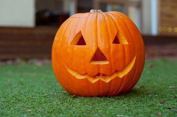 Halloween pumpkin head jack lantern on a grass background