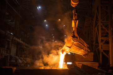 Tank pours liquid metal in the molds at the steel mill - 373868205