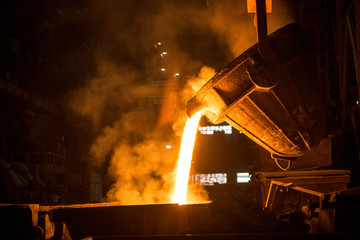 Tank pours liquid metal in the molds at the steel mill - 373868253