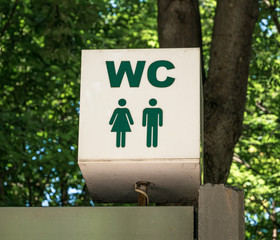 WC toilet sign on top of a public outdoor restroom
