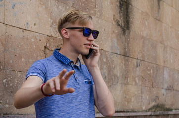 Portrait of young man in sunglasses talking on the phone.