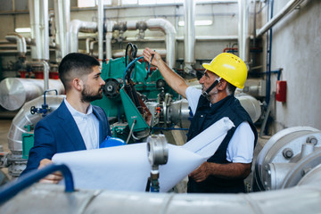 supervisor and worker talking indoor in industry warehouse