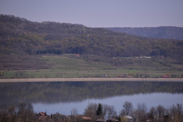Obraz na płótnie Canvas a lake in the village in spring season mirroring the big forest