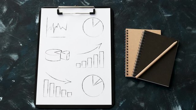 statistics concept, desk with mixed graphs and charts on clipboard and camera tilting