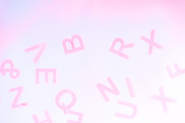 Silhouettes of alphabet letters on pink background. English letters stamp. Top view. Copy space for your creative design
