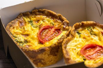 Two little mini tomato tartlets in take-away box close up - Savory mini quiches in a box