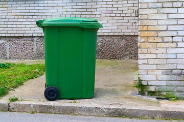 A green dumpster stands near the house