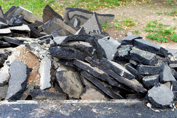 Pieces of asphalt on the side of the road.Reconstruction of the coating