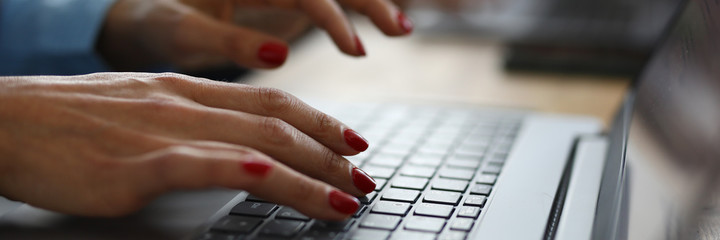 Woman with red nails is typing on keyboard. Online learning professions concept