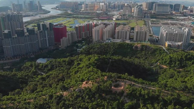 Forwarding tilt reveal aerial of Macau cityscape from Coloane