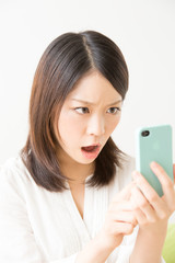 スマホを見て怒る女性