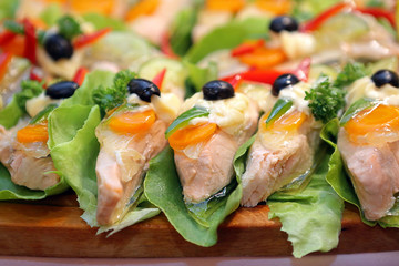 Boiled chicken fillets with olives and vegetables in jelly on the catering table