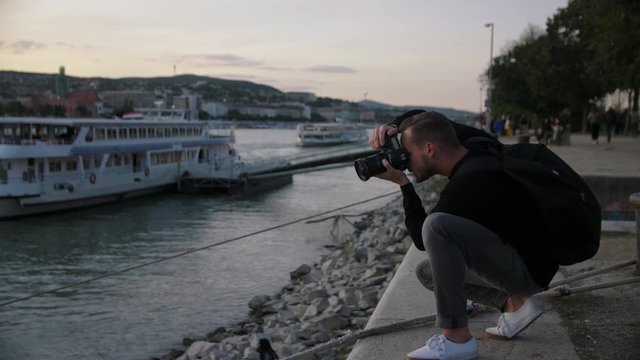 4k footage of tourist or photographer in Budapest at the river Donau taking professional pictures while sunset